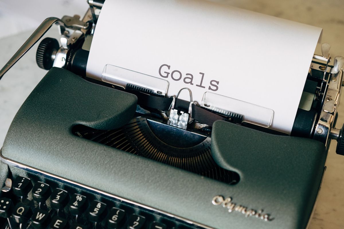 A photo of a typewriter with the word "Goals" written on a piece of paper