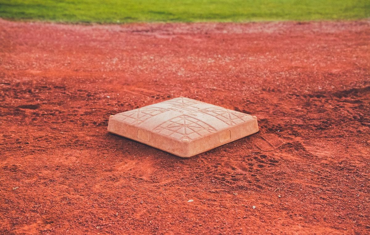 A photo of an empty softball/baseball base on an empty field