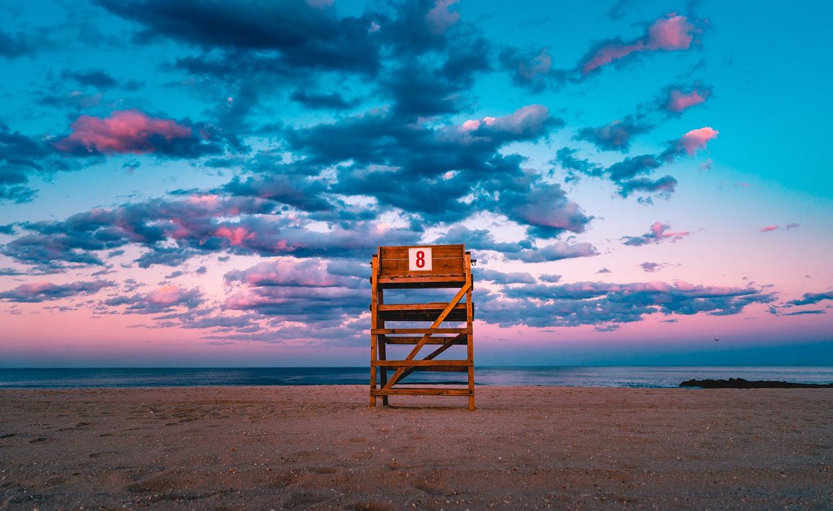 A photo of a beach and a life guard chair showing the number 8