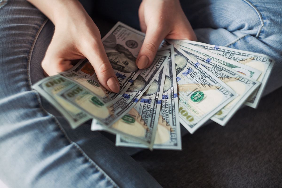 A photo of a women fanning out some $100 bills