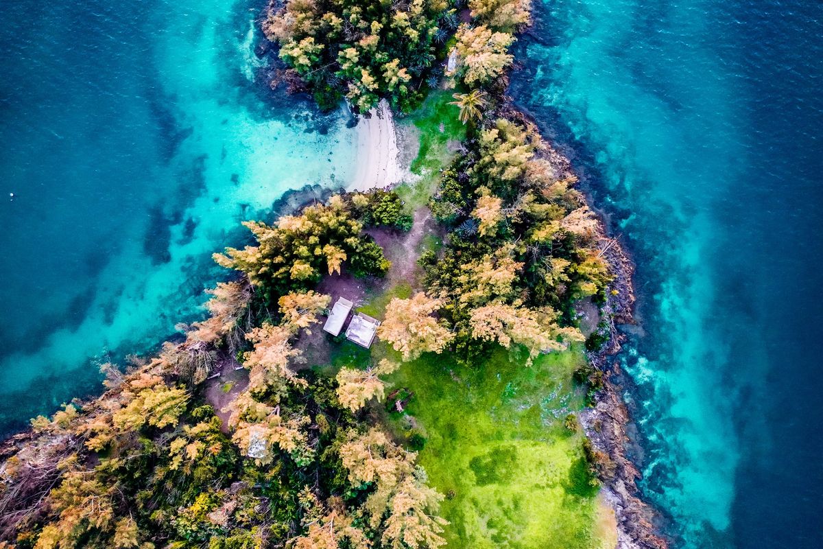 A photo of an island surrounded by blue waters